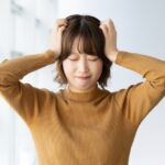 指示が一度に重なって処理が追いつかず頭を抱えて悩む仕事中のイメージ画像