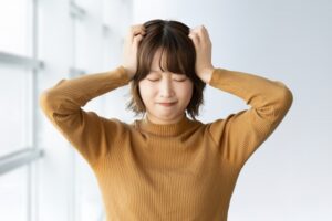 指示が一度に重なって処理が追いつかず頭を抱えて悩む仕事中のイメージ画像