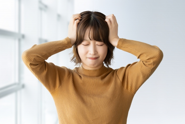 指示が一度に重なって処理が追いつかず頭を抱えて悩む仕事中のイメージ画像